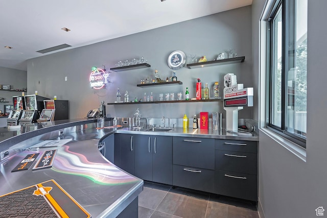 bar featuring a sink, dark tile patterned floors, plenty of natural light, and indoor wet bar