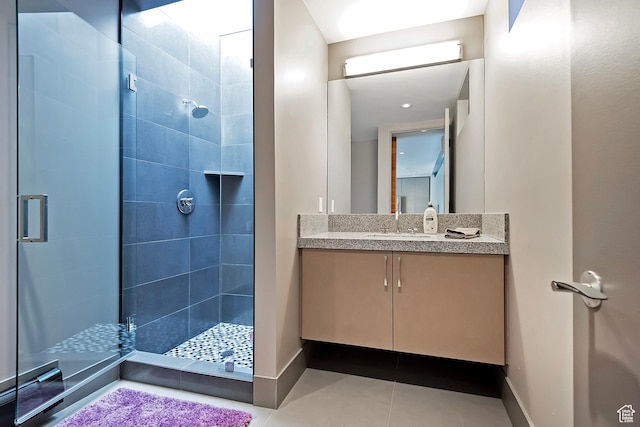 full bathroom featuring a stall shower, vanity, baseboards, and tile patterned floors