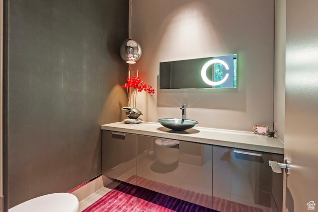 half bathroom with toilet, tile patterned flooring, and vanity