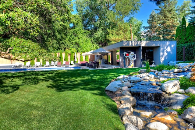 view of yard featuring an outbuilding, an outdoor pool, and a patio