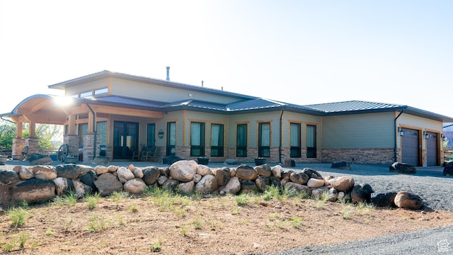 630 W 150 S, Torrey, UT 84775 - rear view of house with stone siding, an attached garage, metal roof, and a standing seam roof