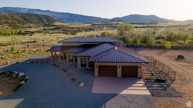 630 W 150 S, Torrey, UT 84775 - view of front of house with a mountain view, an attached garage, metal roof, driveway, and fence