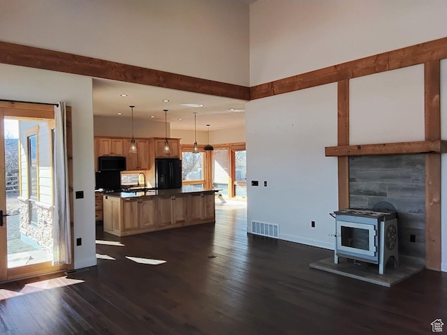 630 W 150 S, Torrey, UT 84775 - unfurnished living room featuring dark wood finished floors, recessed lighting, baseboards, a wood stove, and a sink