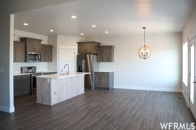 kitchen with recessed lighting, a sink, a chandelier, dark wood-type flooring, and appliances with stainless steel finishes