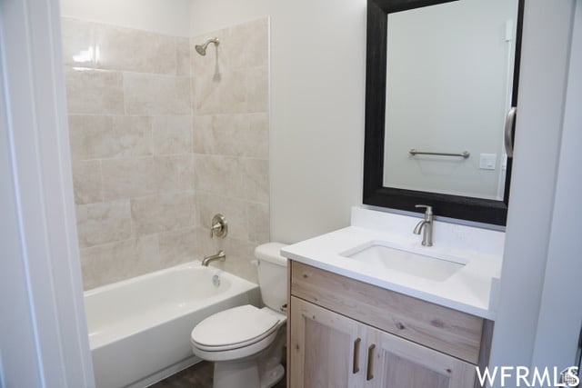 full bath featuring toilet, vanity, and shower / washtub combination