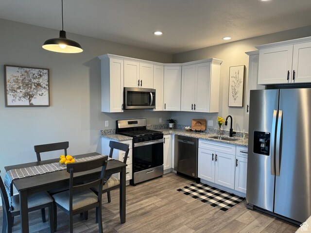 169 E 700 N Unit 14, Ephraim, UT 84627 - kitchen featuring light wood finished floors, light stone counters, stainless steel appliances, white cabinetry, and a sink