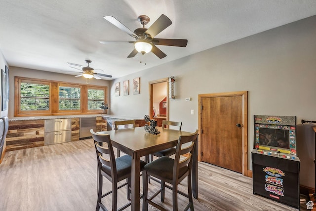 dining room with light wood-style floors and a ceiling fan