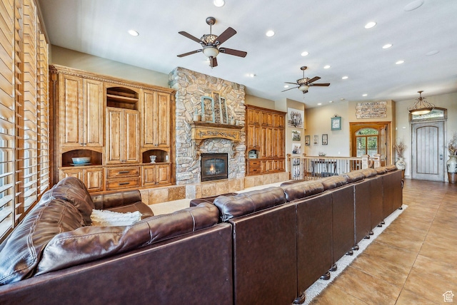 living area featuring a stone fireplace, recessed lighting, light tile patterned floors, and a ceiling fan