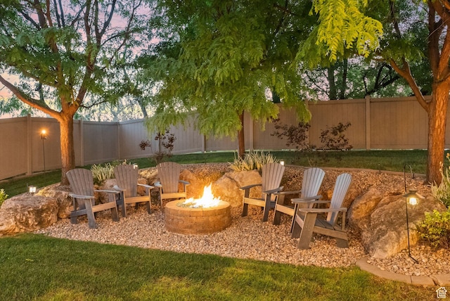 exterior space featuring a fenced backyard and a fire pit