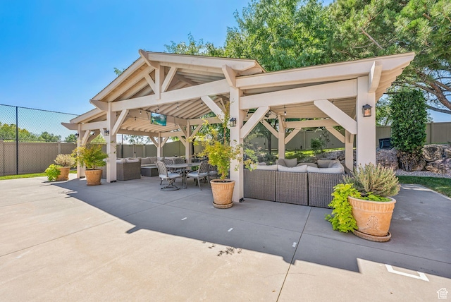 view of patio with outdoor dining area, fence, a gazebo, and an outdoor living space