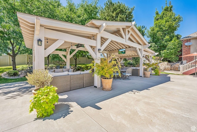 view of patio / terrace with an outdoor hangout area, fence, and a gazebo