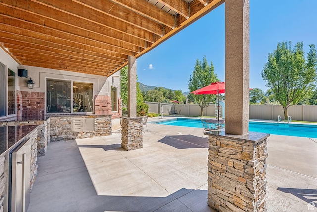view of patio / terrace featuring a fenced backyard, a fenced in pool, and a mountain view