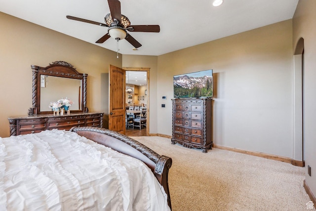carpeted bedroom with baseboards, ceiling fan, and arched walkways