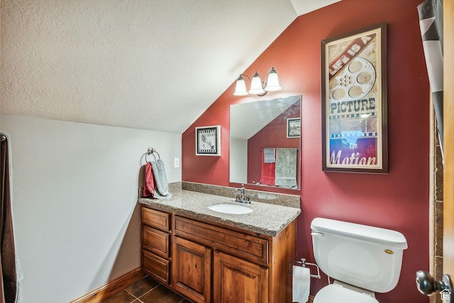bathroom with tile patterned flooring, vanity, vaulted ceiling, toilet, and a textured ceiling