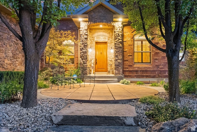 entrance to property with stone siding and brick siding