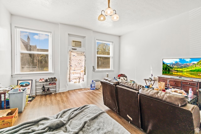 69 S Main St, Manti, UT 84642 - living room with a textured ceiling, wood-type flooring, and an AC wall unit