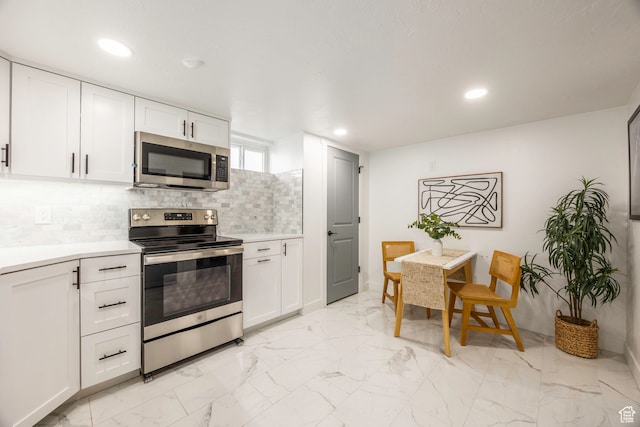 kitchen with light tile patterned floors, white cabinetry, stainless steel appliances, and decorative backsplash