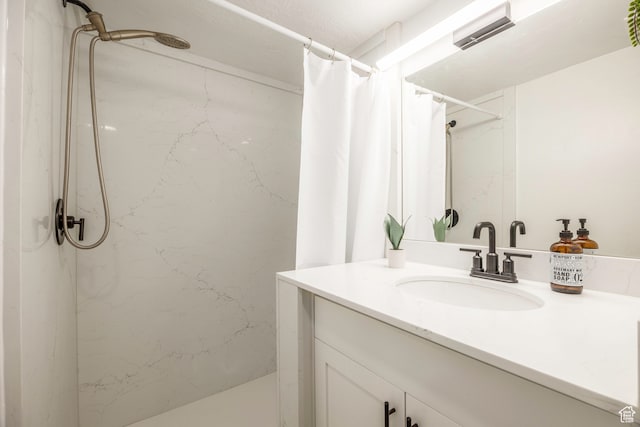 bathroom featuring walk in shower and vanity