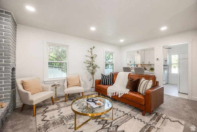 carpeted living room with brick wall
