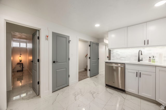 kitchen with dishwasher, white cabinetry, sink, light tile patterned flooring, and decorative backsplash