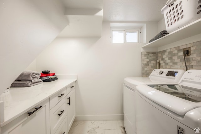 clothes washing area with washing machine and dryer, cabinets, and light tile patterned flooring