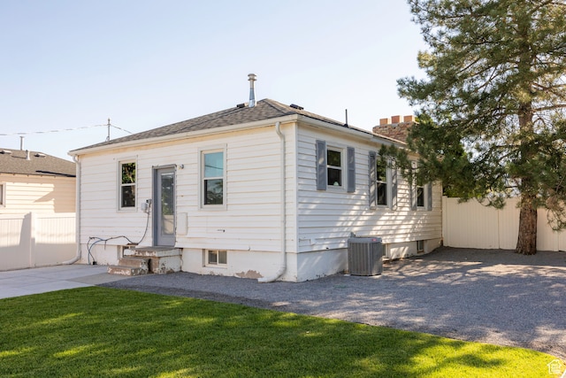 rear view of house featuring a yard and central AC