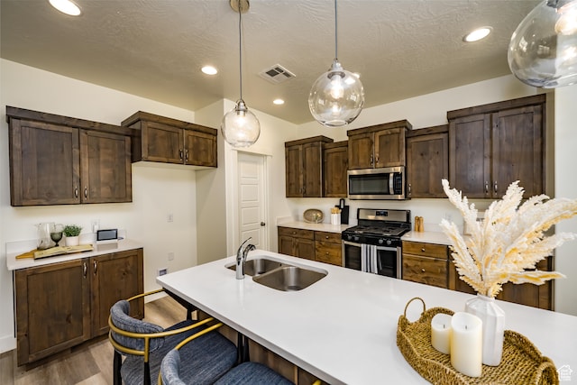 3385 S Marblewood Dr, St George, UT 84790 - kitchen with pendant lighting, wood-type flooring, a kitchen bar, stainless steel appliances, and sink