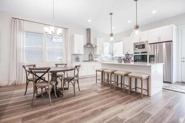 dining space featuring a notable chandelier, recessed lighting, and light wood finished floors