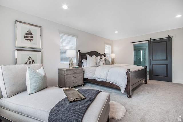 carpeted bedroom featuring a barn door and recessed lighting