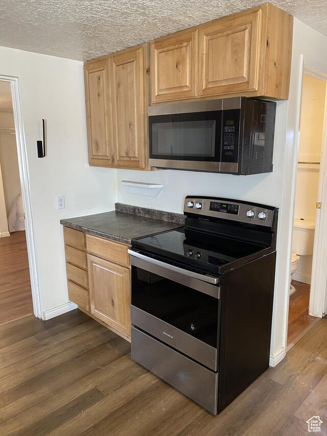 570 W Main St, Green River, UT 84525 - kitchen with dark countertops, appliances with stainless steel finishes, a textured ceiling, and dark wood-type flooring