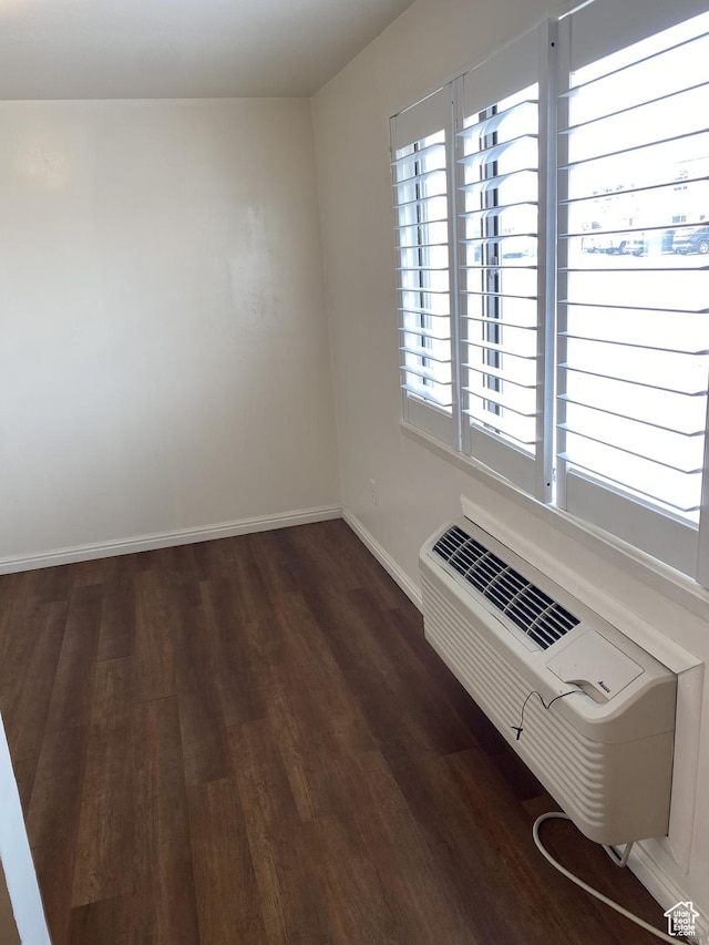 570 W Main St, Green River, UT 84525 - empty room featuring a wall mounted air conditioner, baseboards, and dark wood-style flooring