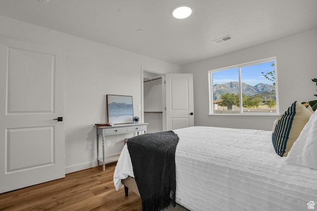 bedroom featuring visible vents, baseboards, and wood finished floors