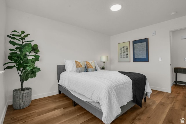 bedroom with baseboards and wood finished floors