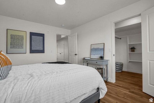 bedroom with wood finished floors and baseboards