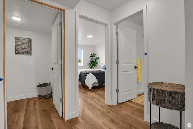 corridor with baseboards and light wood-style floors