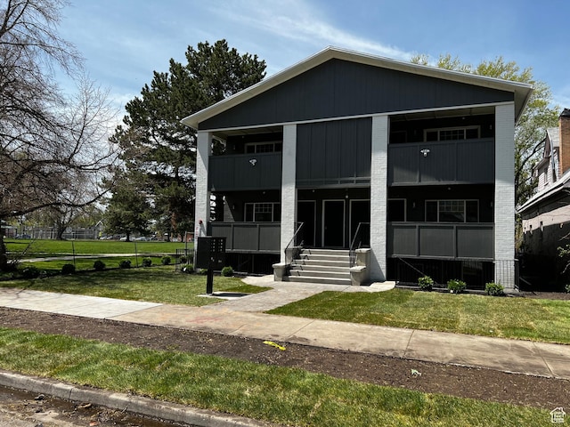 2745 Grant Ave, Ogden, UT 84401 - view of front facade with a balcony, a front yard, and brick siding