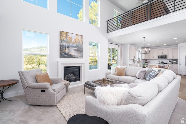 291 E 1980 N, Heber City, UT 84032 - living area featuring baseboards, a glass covered fireplace, a high ceiling, a notable chandelier, and recessed lighting
