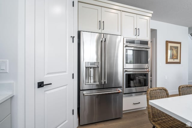 291 E 1980 N, Heber City, UT 84032 - kitchen featuring dark wood finished floors, stainless steel appliances, white cabinetry, a textured ceiling, and baseboards