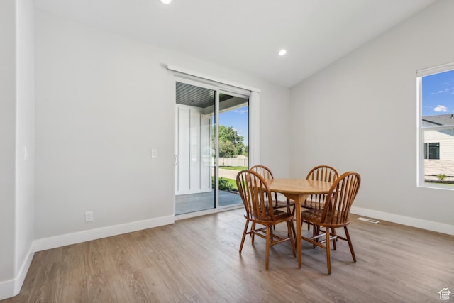 dining room featuring baseboards, wood finished floors, vaulted ceiling, and recessed lighting