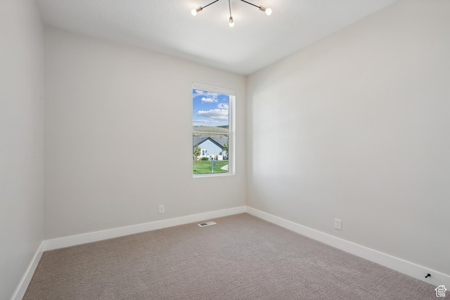unfurnished room featuring baseboards, visible vents, and carpet
