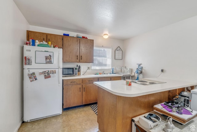 535 N 700 E Unit 1-4, Spanish Fork, UT 84660 - kitchen featuring freestanding refrigerator, stainless steel microwave, light countertops, a breakfast bar, and a peninsula