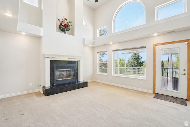 678 Eagle Way, Fruit Heights, UT 84037 - unfurnished living room featuring a towering ceiling, a tile fireplace, baseboards, and carpet floors