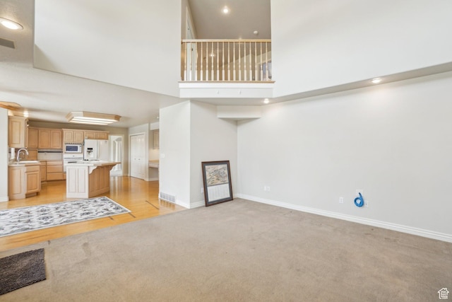 678 Eagle Way, Fruit Heights, UT 84037 - unfurnished living room with light carpet, baseboards, visible vents, and a high ceiling