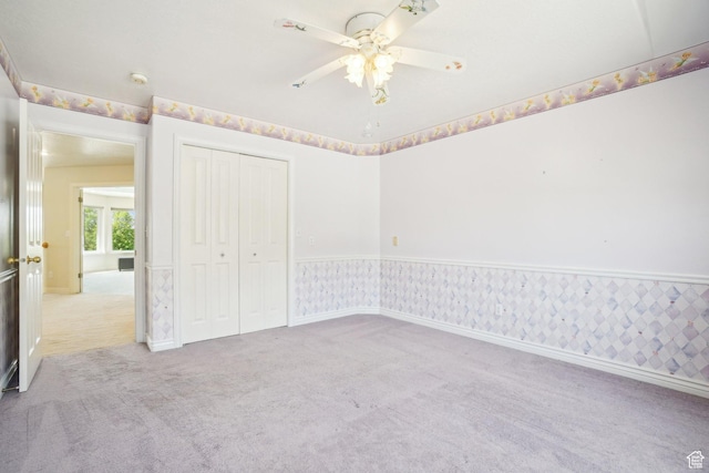 678 Eagle Way, Fruit Heights, UT 84037 - unfurnished bedroom with baseboards, wallpapered walls, a ceiling fan, a closet, and carpet floors