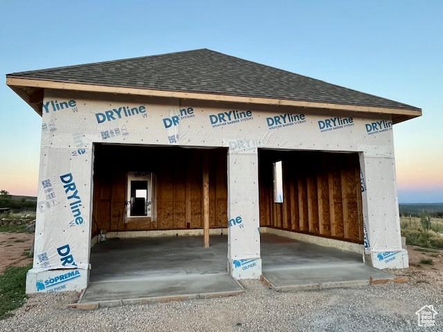 exterior space featuring roof with shingles and a garage