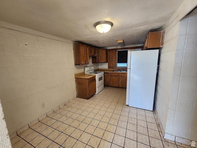 370 W 620 N, Castle Dale, UT 84513 - kitchen with brown cabinets, a sink, white appliances, concrete block wall, and light countertops