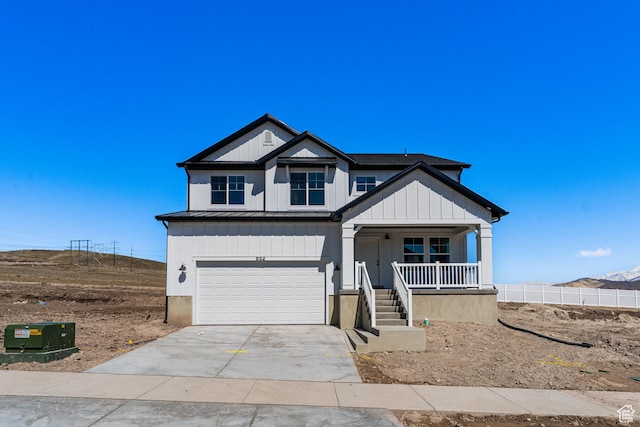 view of front of home featuring a standing seam roof, metal roof, covered porch, driveway, and an attached garage