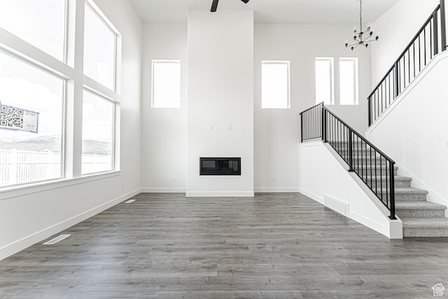 652 W Salvia Dr Unit 2144, Saratoga Springs, UT 84045 - unfurnished living room featuring stairway, a high ceiling, a chandelier, wood finished floors, and baseboards