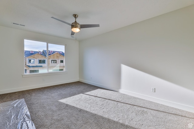 carpeted empty room with a ceiling fan, baseboards, and visible vents