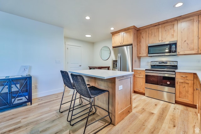 kitchen featuring recessed lighting, light wood-style flooring, appliances with stainless steel finishes, and a kitchen island